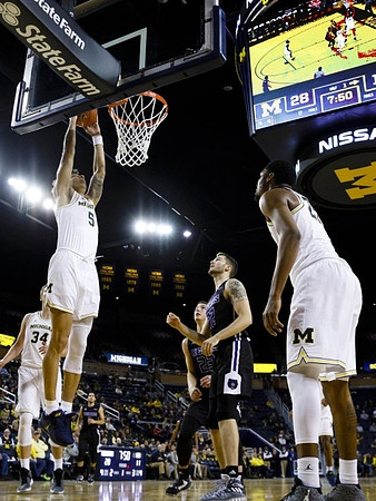Mark Donnal (34), D.J. Wilson (5), and Zak Irvin (21)