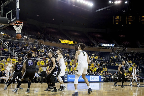 Duncan Robinson (22), Mark Donnal (34), and D.J. Wilson (5)