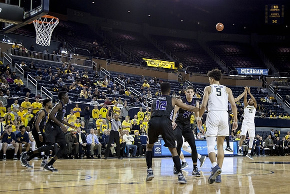 D.J. Wilson (5) and Zak Irvin (21)