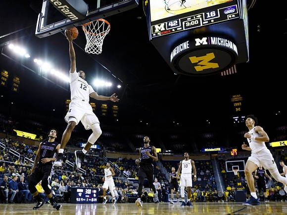 Muhammad-Ali Abdur-Rahkman (12), Zak Irvin (21), Derrick Walton Jr. (10), and D.J. Wilson (5)