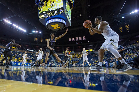 Zak Irvin (21), Duncan Robinson (22), Xavier Simpson (3), and Mark Donnal (34)
