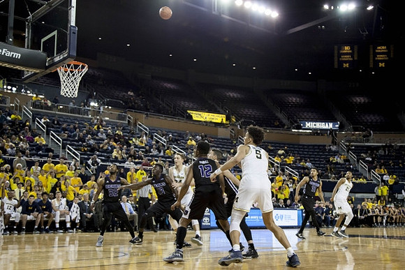 Mark Donnal (34), D.J. Wilson (5), and Zak Irvin (21)