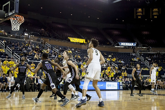Mark Donnal (34), D.J. Wilson (5), and Zak Irvin (21)