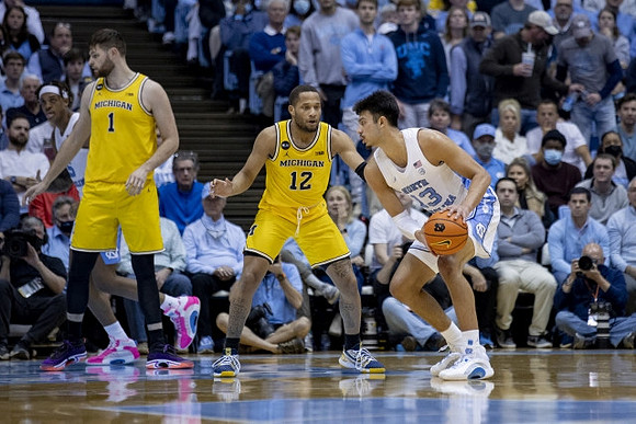 Hunter Dickinson (1) and DeVante' Jones (12)