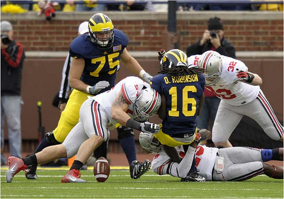 Michael Schofield (75) and Denard Robinson (16)
