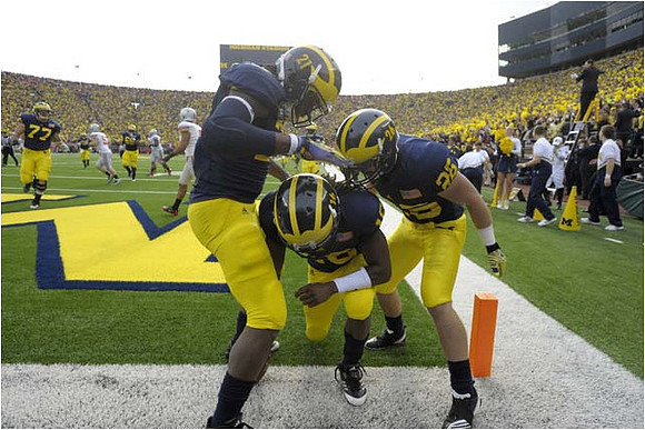 Taylor Lewan (77), Junior Hemingway (21), Denard Robinson (16), and Drew Dileo (26)