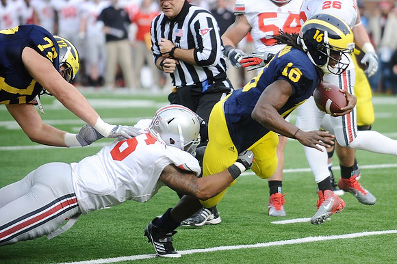 Mark Huyge (72) and Denard Robinson (16)