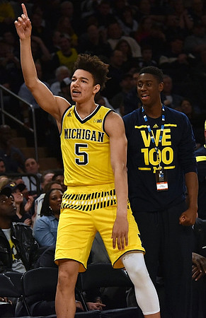 D.J. Wilson (5) and Caris LeVert (23)
