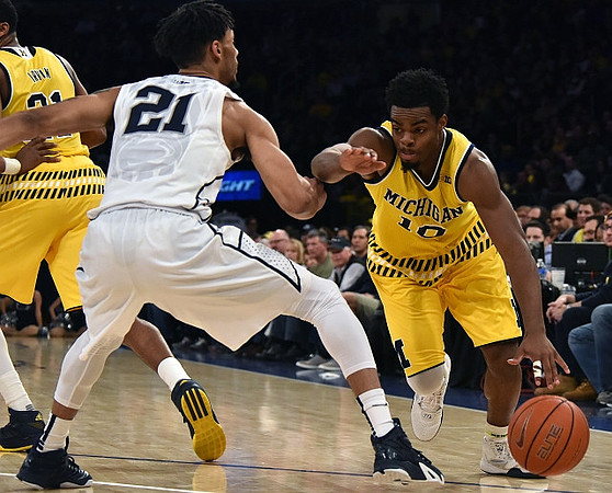 Zak Irvin (21) and Derrick Walton Jr. (10)
