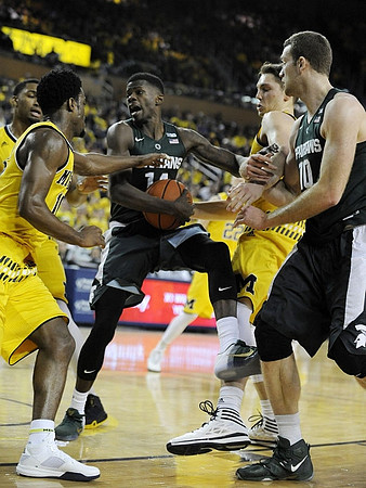 Zak Irvin (21), Derrick Walton Jr. (10), and Mark Donnal (34)