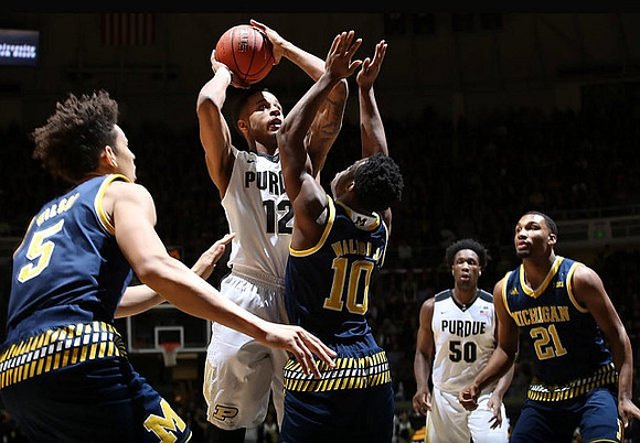 D.J. Wilson (5), Derrick Walton Jr. (10), and Zak Irvin (21)