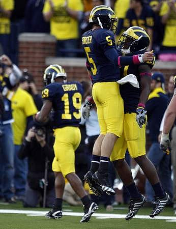 Kelvin Grady (19), Tate Forcier (5), and Junior Hemingway (21)
