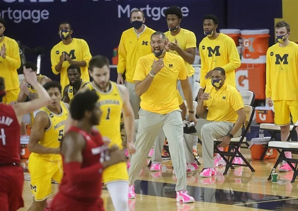 Eli Brooks (55), Hunter Dickinson (1), Juwan Howard, and Michigan Team