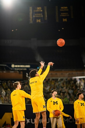 Eli Brooks (55), Franz Wagner (21), and Michigan Team