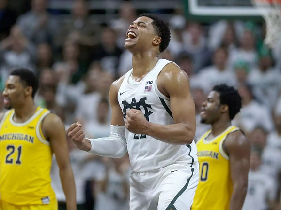 Zak Irvin (21) and Derrick Walton Jr. (10)
