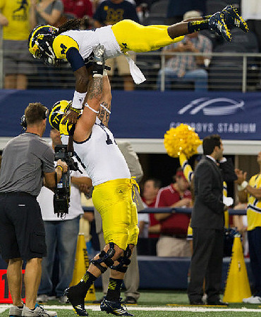 Taylor Lewan (77) and Denard Robinson (16)