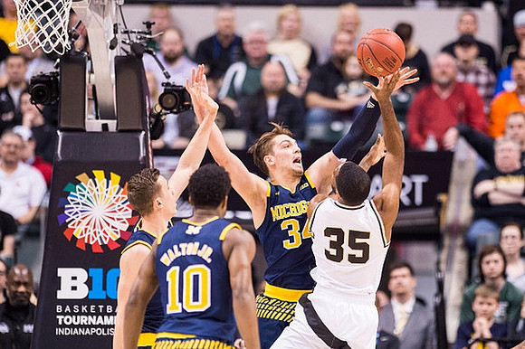 Duncan Robinson (22), Derrick Walton Jr. (10), and Mark Donnal (34)