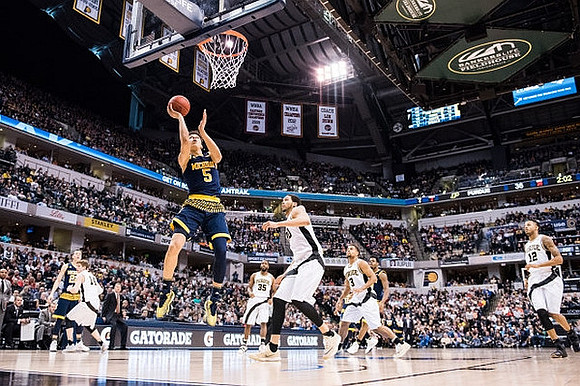 Duncan Robinson (22), D.J. Wilson (5), and Derrick Walton Jr. (10)