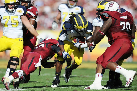 Michael Schofield (75) and Denard Robinson (16)