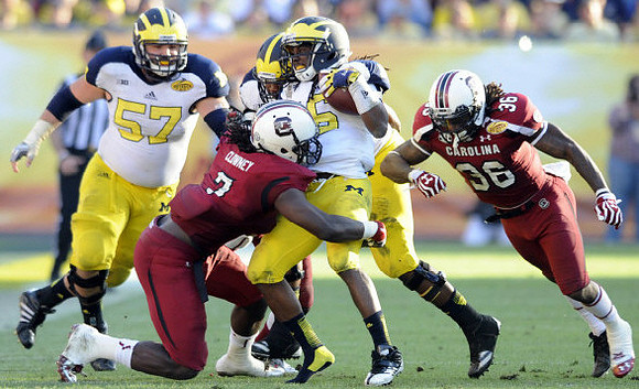 Elliott Mealer (57) and Denard Robinson (16)