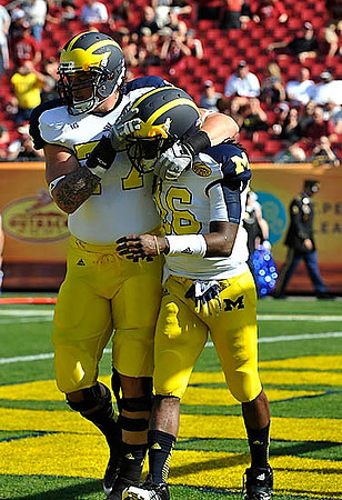 Taylor Lewan (77) and Denard Robinson (16)