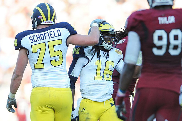 Michael Schofield (75) and Denard Robinson (16)