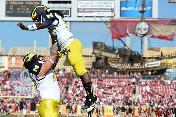 Taylor Lewan (77) and Denard Robinson (16)