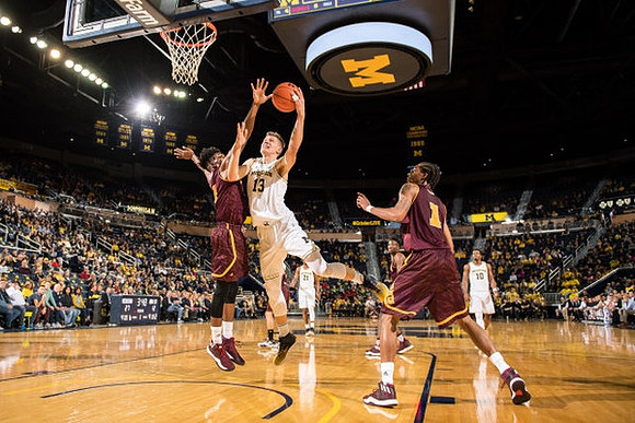 Moritz Wagner (13), Zak Irvin (21), and Derrick Walton Jr. (10)