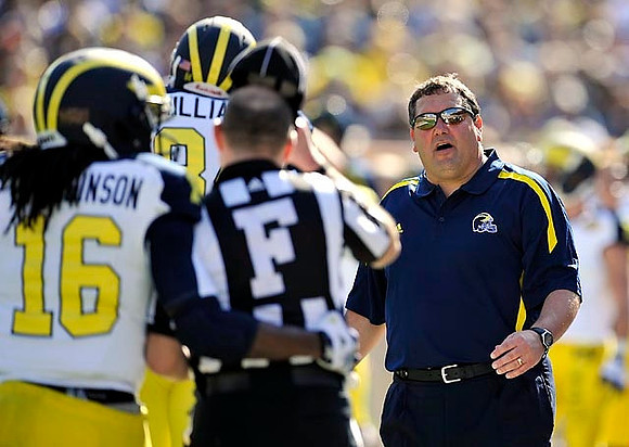 Denard Robinson (16), Brady Hoke, and A.J. Williams (84)