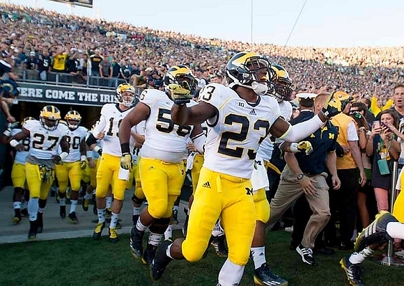 Dennis Norfleet (23), Ondre Pipkins (56), Derrick Green (27), and Michigan Team