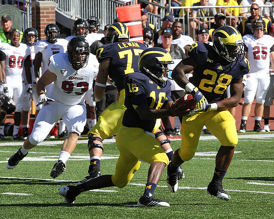Taylor Lewan (77), Denard Robinson (16), and Fitzgerald Toussaint (28)
