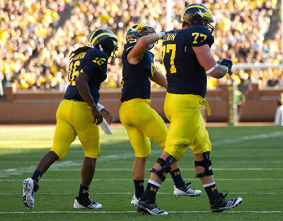 Denard Robinson (16), Drew Dileo (9), and Taylor Lewan (77)