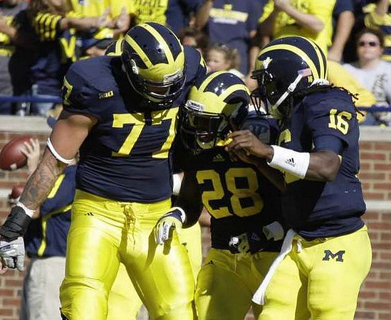 Taylor Lewan (77), Fitzgerald Toussaint (28), and Denard Robinson (16)
