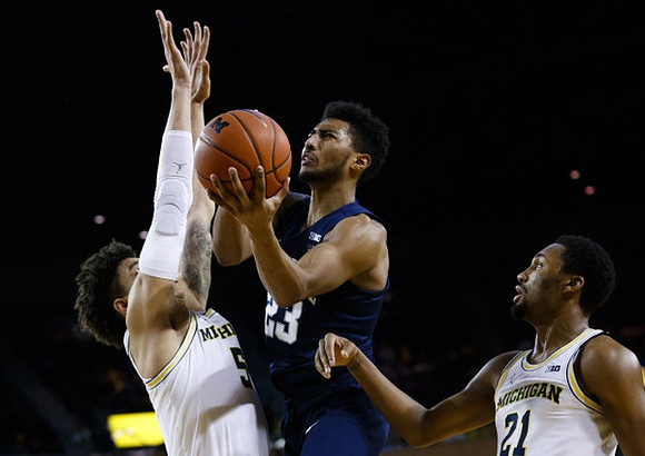 D.J. Wilson (5) and Zak Irvin (21)