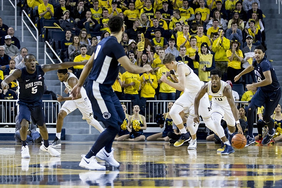 Derrick Walton Jr. (10), Zak Irvin (21), and Moritz Wagner (13)