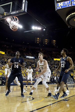 D.J. Wilson (5), Muhammad-Ali Abdur-Rahkman (12), and Moritz Wagner (13)