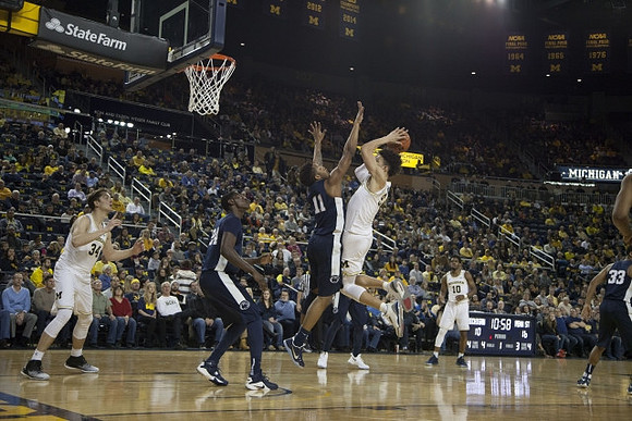Mark Donnal (34), D.J. Wilson (5), and Derrick Walton Jr. (10)