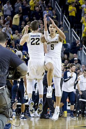 Duncan Robinson (22) and D.J. Wilson (5)