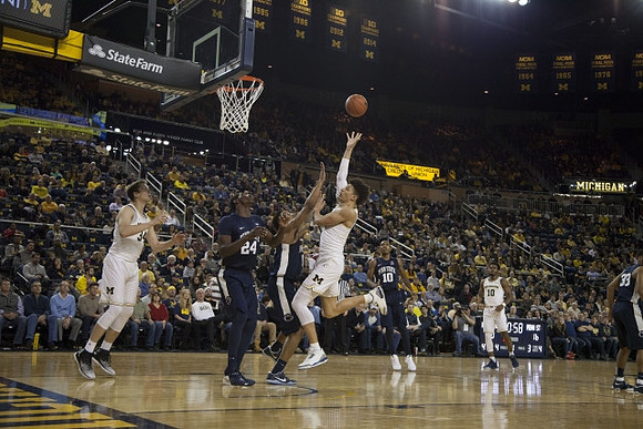 Mark Donnal (34), D.J. Wilson (5), and Derrick Walton Jr. (10)