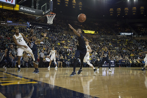 Zak Irvin (21), D.J. Wilson (5), and Mark Donnal (34)