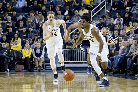 Mark Donnal (34) and Derrick Walton Jr. (10)