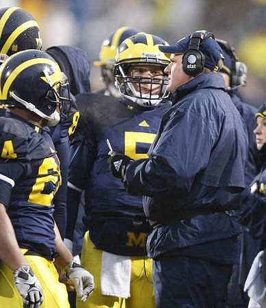 Kevin Grady (24), Tate Forcier (5), and Rich Rodriguez