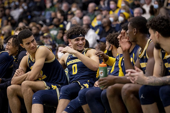 Caleb Houstan (22), Adrien Nunez (0), and Michigan Team