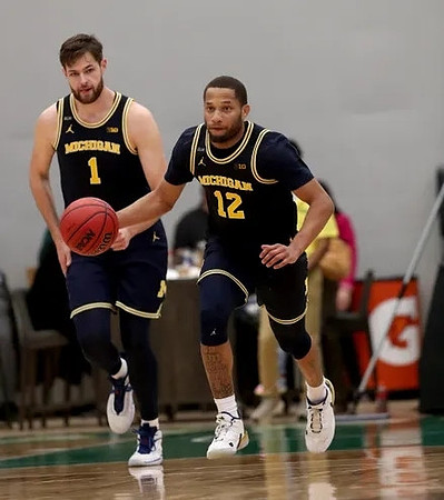 Hunter Dickinson (1) and DeVante' Jones (12)