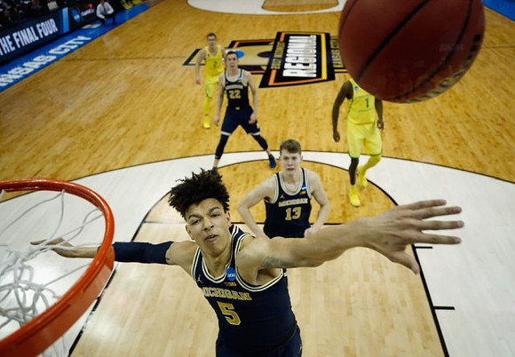 D.J. Wilson (5), Moritz Wagner (13), and Duncan Robinson (22)