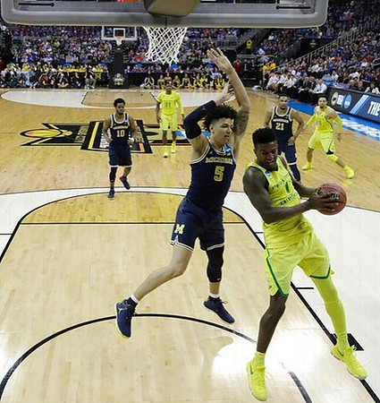 Derrick Walton Jr. (10), D.J. Wilson (5), and Zak Irvin (21)