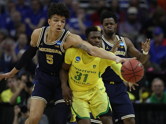 D.J. Wilson (5) and Derrick Walton Jr. (10)