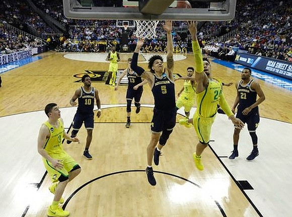 Derrick Walton Jr. (10), Moritz Wagner (13), D.J. Wilson (5), and Zak Irvin (21)