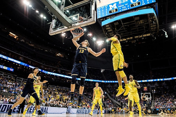 D.J. Wilson (5), Moritz Wagner (13), and Derrick Walton Jr. (10)