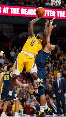 Eli Brooks (55), David DeJulius (0), and Minnesota Head Coach Richard Pitino